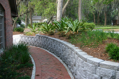 Design ideas for a tropical partial sun backyard concrete paver retaining wall landscape in Miami for summer.