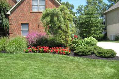 This is an example of a large front full sun garden in Columbus with a potted garden.