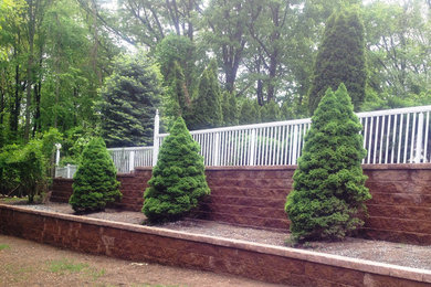 Photo of a mid-sized backyard stone retaining wall landscape in New York.