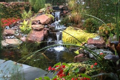 Photo of a large transitional full sun backyard water fountain landscape in Other for spring.