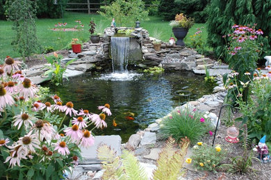 Diseño de jardín clásico en verano en patio trasero con estanque, exposición total al sol y mantillo