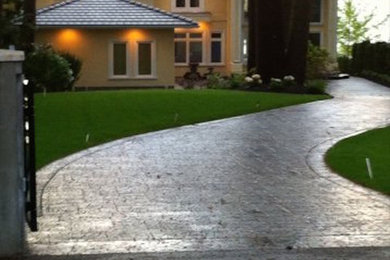 Design ideas for a large traditional courtyard concrete paver driveway in Vancouver.
