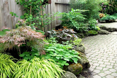Foto de jardín de tamaño medio en patio trasero con jardín de macetas, exposición total al sol y adoquines de piedra natural