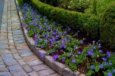Photo of a mid-sized traditional full sun side yard brick landscaping in New York.