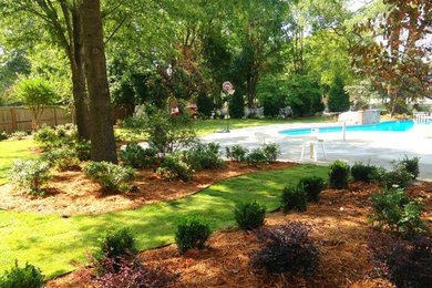 Large classic back partial sun garden in Little Rock with a garden path and mulch.