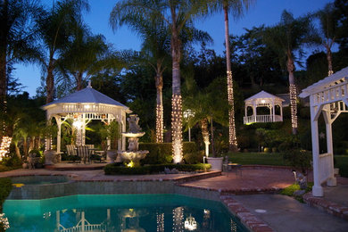 Expansive classic back fully shaded garden in Orange County with brick paving.