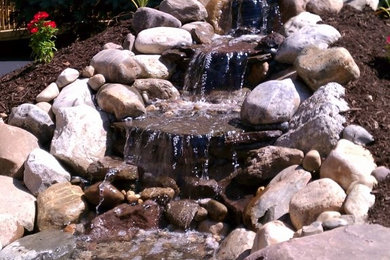 Design ideas for a mid-sized partial sun front yard stone water fountain landscape in DC Metro.