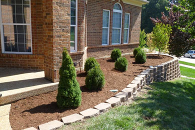 This is an example of a large traditional front yard brick retaining wall landscape in St Louis.