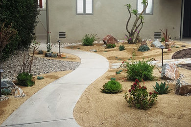 This is an example of a mid-sized southwestern drought-tolerant and partial sun backyard stone landscaping in San Diego for summer.
