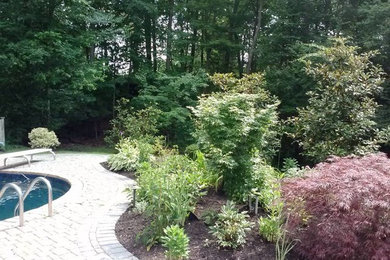 Modelo de jardín clásico grande en patio trasero con adoquines de ladrillo