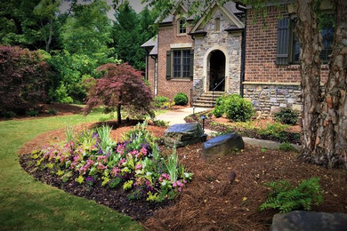 Photo of a large traditional partial sun front yard mulch formal garden in Atlanta.