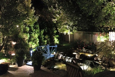 Ejemplo de jardín clásico de tamaño medio en patio trasero con estanque y adoquines de hormigón