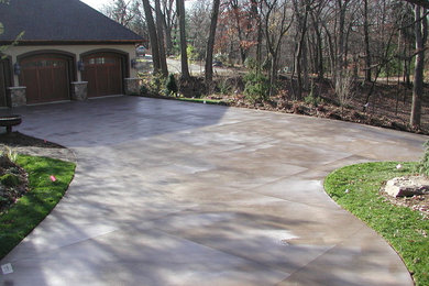 This is an example of a large traditional partial sun front yard concrete paver driveway in Minneapolis.