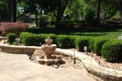 This is an example of a mid-sized traditional full sun front yard concrete paver landscaping in Other.