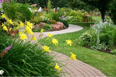 This is an example of a mid-sized traditional full sun side yard concrete paver landscaping in Other.