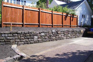 Design ideas for a large classic front partial sun garden in Portland with a retaining wall and natural stone paving.