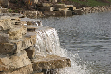Photo of a huge traditional full sun hillside water fountain landscape in Milwaukee for summer.