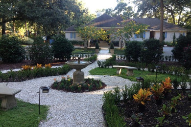 Ejemplo de jardín tradicional grande en patio con fuente, jardín francés, exposición parcial al sol y gravilla