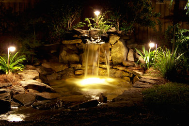 Inspiration for a large shade backyard water fountain landscape in Other.