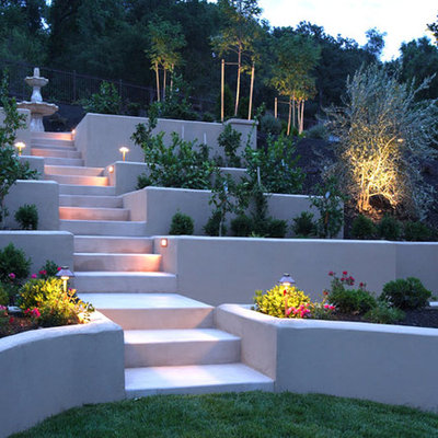 This is an example of a mid-sized contemporary partial sun backyard concrete paver retaining wall landscape in Orange County.