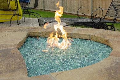 Photo of a mid-sized contemporary full sun backyard stone landscaping in Miami with a fire pit for fall.