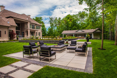 Inspiration for a large transitional full sun backyard concrete paver landscaping in Toronto with a fire pit.