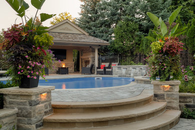 Design ideas for a large transitional full sun backyard stone landscaping in Toronto for summer.