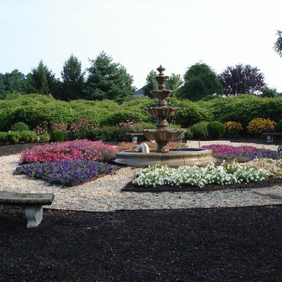 This is an example of a mid-sized traditional partial sun backyard landscaping in Other.