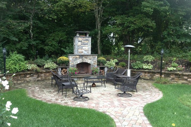 Foto de jardín clásico de tamaño medio en patio trasero con jardín francés, brasero, exposición parcial al sol y adoquines de piedra natural