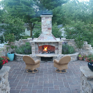 Mittelgroßer Moderner Garten neben dem Haus mit Kamin, direkter Sonneneinstrahlung und Betonplatten in Milwaukee