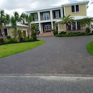 Ispirazione per un grande vialetto d'ingresso tropicale davanti casa con pavimentazioni in mattoni