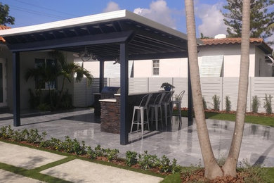 Diseño de jardín tropical grande en patio trasero con adoquines de hormigón