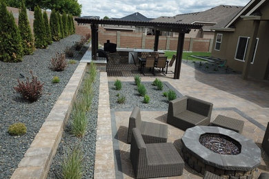 Imagen de jardín moderno de tamaño medio en patio trasero con brasero, exposición parcial al sol y adoquines de hormigón