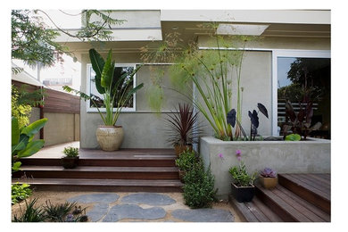Cette image montre un petit jardin arrière design avec un point d'eau et une terrasse en bois.