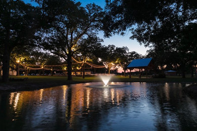 Photo of a large rustic drought-tolerant and partial sun concrete paver pond in Austin for summer.