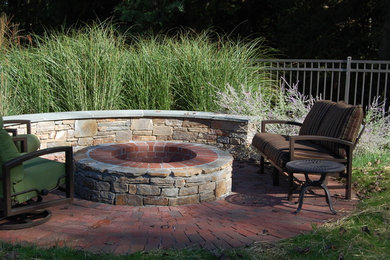 Design ideas for a small rustic full sun backyard brick landscaping in Philadelphia with a fire pit.