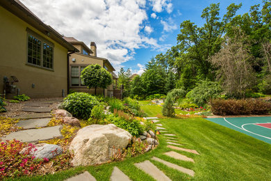 Großer, Halbschattiger Klassischer Gartenweg im Sommer, hinter dem Haus mit Sportplatz und Natursteinplatten in Minneapolis