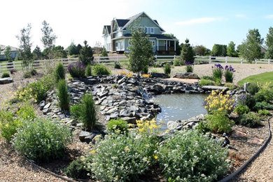This is an example of a large modern drought-tolerant and full sun side yard gravel water fountain landscape in Denver.
