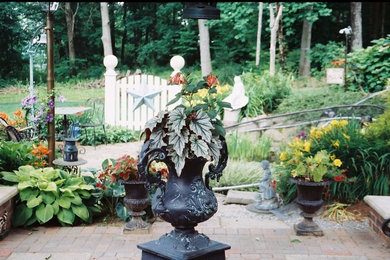 Ejemplo de jardín campestre de tamaño medio en verano en patio trasero con adoquines de hormigón, estanque, exposición total al sol y jardín francés
