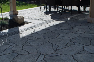 Medium sized back patio in Toronto with concrete paving.