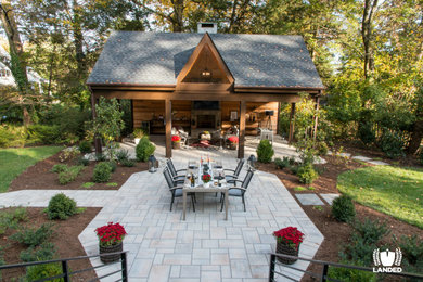 Photo of a large partial sun backyard stone landscaping in DC Metro with a fireplace.