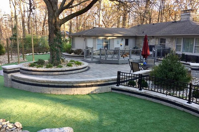Modelo de jardín de estilo americano grande en patio trasero con exposición total al sol y adoquines de piedra natural