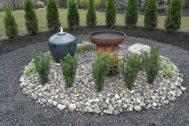 Photo of a mid-sized contemporary partial sun backyard gravel water fountain landscape in New York.