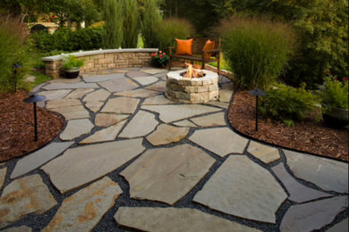 Foto de patio clásico de tamaño medio en patio trasero con brasero y adoquines de piedra natural