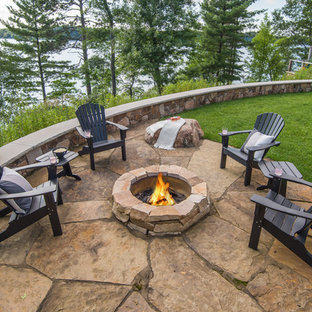 Geräumiger Garten im Sommer, hinter dem Haus mit Auffahrt, Kamin, direkter Sonneneinstrahlung und Natursteinplatten in Minneapolis