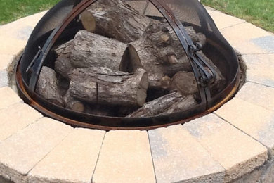This is an example of a backyard concrete paver landscaping in New York with a fire pit.