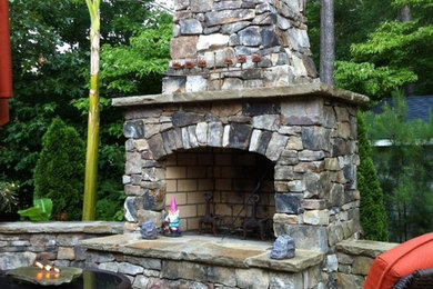 Example of a small classic backyard stone patio design in Atlanta with a fireplace