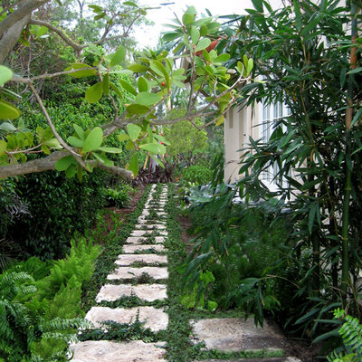 Photo of a mid-sized traditional side yard stone landscaping in Miami.