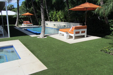 This is an example of a mid-sized contemporary drought-tolerant and partial sun backyard concrete paver landscaping in Miami.