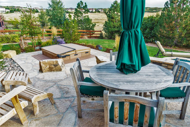 Photo of a mid-sized contemporary backyard stone landscaping in Denver.
